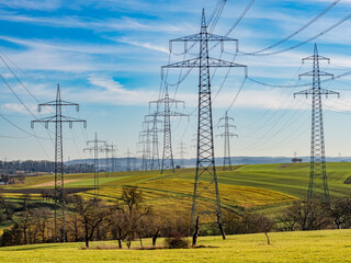 Hochspannungsmasten einer &Uuml;berlandleitung in h&uuml;geliger Landschaft