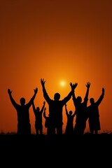 Silhouettes of diverse adults celebrating against orange sunset