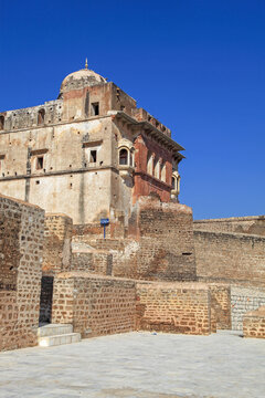 View of an old building with stone walls and a dome against a vivid blue sky, creating a stark contrast in Katas, Punjab, Pakistan.