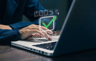 A business professional uses a laptop with ISO certification and approval icons, representing quality management systems, compliance standards, audit processes, risk control.