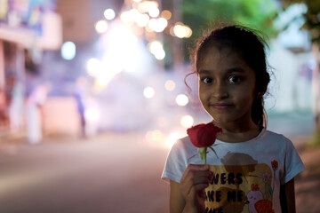 Girl holding rose during festival celebration in evening