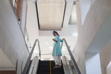 Woman standing on escalator in a modern building