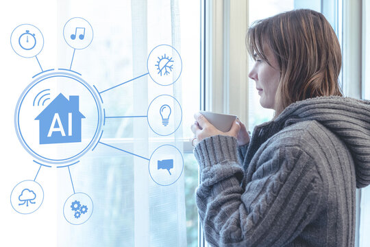Young woman wearing a grey knit sweater holding a cup of hot drink stands by a window in her smart home controlled by an artificial intelligence system that manages heating and lighting automation - Powered by Adobe