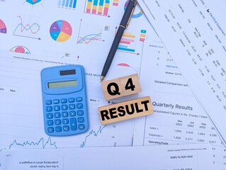   
q4 financial results analysis with charts, calculator, pen, and wooden blocks on business performance documents
