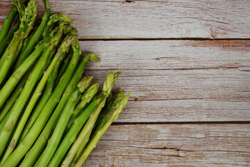 Bunch of fresh green asparagus stems on wooden background