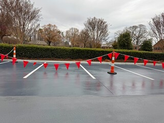 Red flags hang over a freshly paved parking lot