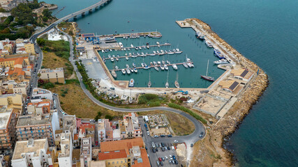 Obraz premium Aerial view of the small marina in Augusta, in the province of Syracuse, Sicily, Italy. It's a small marina close to the town centre overlooking the Mediterranean Sea. There are boats in the harbour.