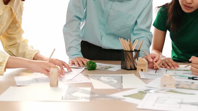 A video of architect use measurement tools and pencil to measure blueprint. Architect design house construction on a table at studio, with architectural plan scattered around. Focus hand. Delineation.