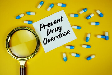 Prevent Drug Overdose  with medicine capsule and magnifying glass on green background