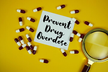 Prevent Drug Overdose  with medicine capsule and magnifying glass on green background