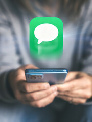 Receiving an Important Digital Message A Woman Holds a Phone While a Large Text Bubble Floats Above It