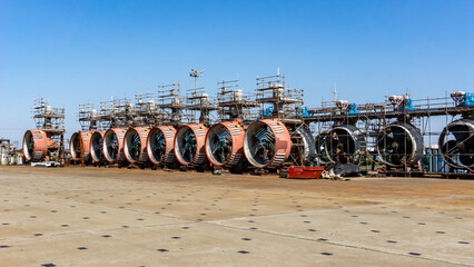 View of massive, dormant turbine engines stand in silent formation under a vast, clear sky, their metallic surfaces reflecting the stark light, Shanghai, Shanghai, China.