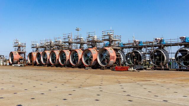 View of massive, dormant turbine engines stand in silent formation under a vast, clear sky, their metallic surfaces reflecting the stark light, Shanghai, Shanghai, China.