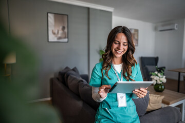 Smiling female nurse using tablet for home care digital health