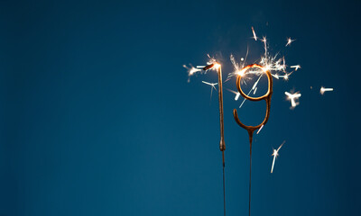 19 years celebration festive background with copy space made with Bengal fires in the form of number Nineteen.