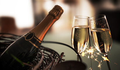 Champagne bottle with two filled glasses for a toast. Atmospheric background with a lit sparkler for special moments.