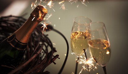 Champagne bottle with two filled glasses for a toast. Atmospheric background with a lit sparkler for special moments.