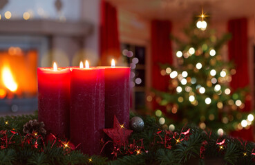Four burning red Advent candles isolated on glowing Christmas tree background.