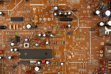 A close-up of a brown printed circuit board from a computer or electronic device. Concept of electronics and microprocessor technology
