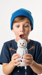 Surprised boy in blue beanie looking at melting snowman toy. Funny childhood expression of wonder and shock isolated on white background