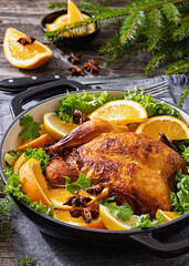 Whole roasted chicken in baking dish with citrus