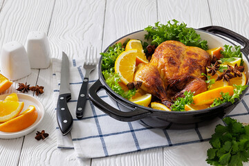 Whole roasted chicken in baking dish with citrus