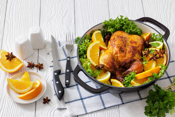 Whole roasted chicken in baking dish with citrus