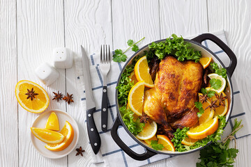 Whole roasted chicken in baking dish with citrus