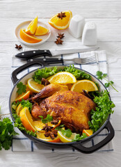 Whole roasted chicken in baking dish with citrus