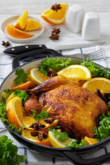 Whole roasted chicken in baking dish with citrus