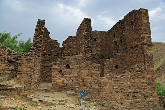 View of ancient stone ruins standing strong against the backdrop of rugged hills and an overcast sky, a testament to history, Takht Bhai, Khyber Pakhtunkhwa, Pakistan.