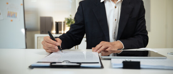 Closeup image businessman sitting at desk signing contract