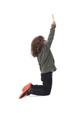 side view of a kneeling child painting and looking up with a brush on white background