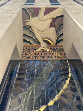 View of a striking bas-relief sculpture above an entrance, its art deco style and biblical quote creating a timeless scene, New York, New York, United States.