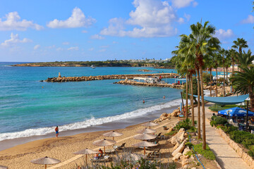 Obraz premium Coral Bay is a crescent-shaped beach near Paphos known for its soft, golden sand and calm, shallow waters, which make it ideal for families and swimming