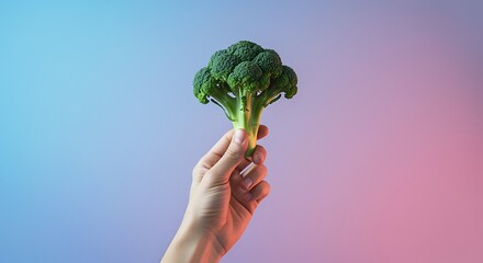 hand holding green broccoli against colorful background