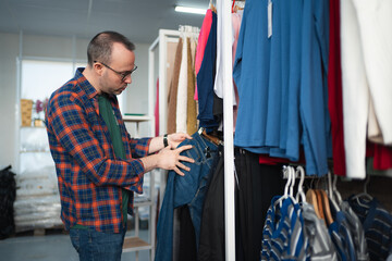 Man shopping for denim jeans in clothing store