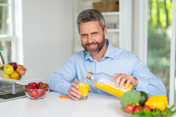Mature man eating lunch. Morning at home. Breakfast in kitchen. Man eating organic vegetable and juice for lunch. Enjoying healthy food. Man eat morning breakfast in kitchen. Healthy and happy