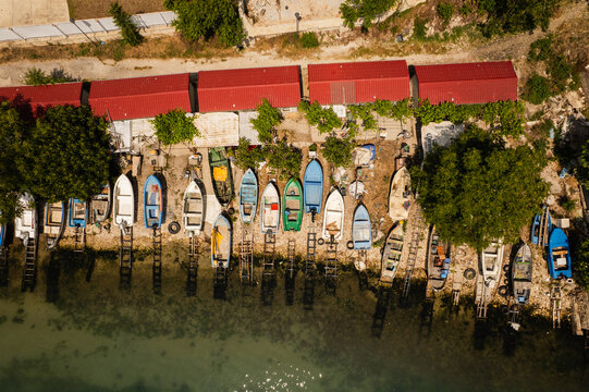 Aerial view of boats lined up along the shore near red-roofed buildings, a vibrant contrast of colors and textures against the tranquil water, Balchik, Dobrich Province, Bulgaria.