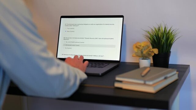 Middle Aged Male Cybersecurity Analyst Conducts Third Party Risk Assessment on Outside Vendor