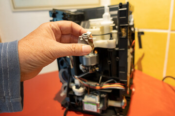 Eine Kaffemaschiene wird repariert von einer Frau 