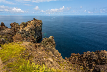 Dramatic volcanic cliffs at Alagoa Viewpoint overlooking the deep blue Atlantic Ocean on Terceira Island, Azores, Portugal, showcasing rugged lava coast scenery and natural beauty