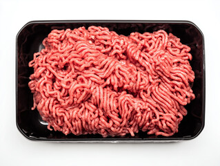 Top-down view of fresh raw minced beef packaged in a black tray isolated on a white background.