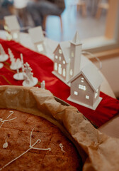 The photo shows a New Year cake shaped like a snowflake placed on a surface. Holiday dessert, winter theme, festive baking, close-up view, neutral background, soft natural light.