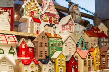 Bright miniature ceramic houses arranged as a tiny winter village display, with detailed windows and roofs, ideal for Christmas decor, seasonal storytelling, and cozy interior styling concepts.