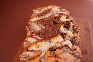 close-up of sliced marble cake showcasing rich chocolate and vanilla swirls on wood cutting board...