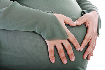 Pregnant muslim woman making heart shape with hands