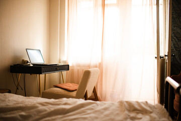 Cozy home interior with bed and working place in sun light. Warm hygge atmosphere.