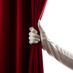 Dramatic hand in white glove pulling back red velvet curtain