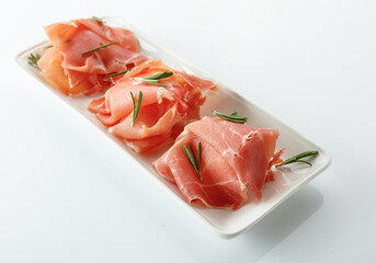 Delicious prosciutto slices with rosemary.